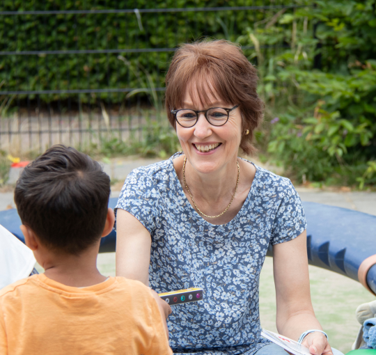 Pedagogisch medewerker met kindje op een speelplaats
